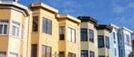A row of multi-story, colorful townhouses