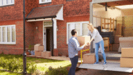 An image of a couple unloading the truck with their moving items on a checklist.
