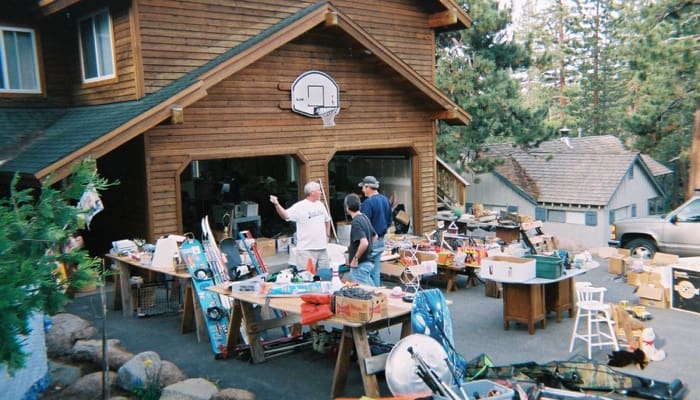 A man downsizing his home by selling belongings in a garage sale.