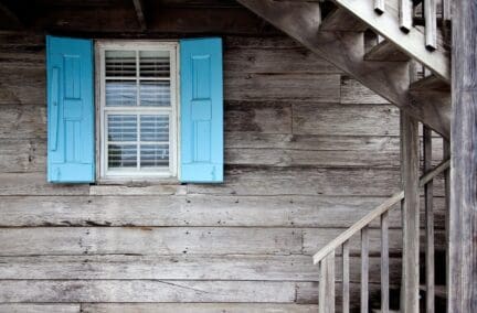 Brown house with blue shutters before home inspection.