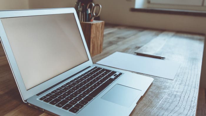 Computer and blank paper for research to upgrade out of small house with kids.