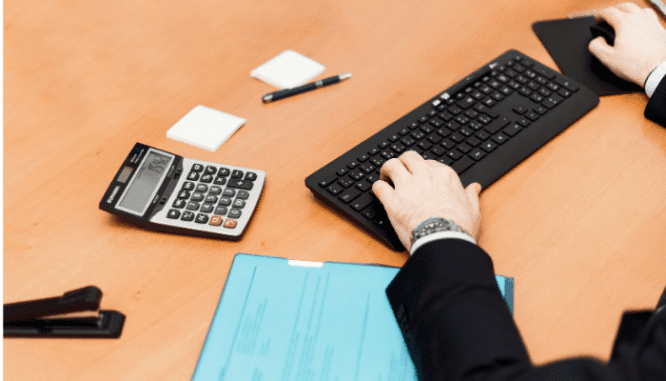 A real estate agent with a calculator in order to tell what would be a low down payment.