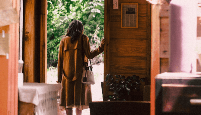 A woman leaving her house so it can get apprasied.