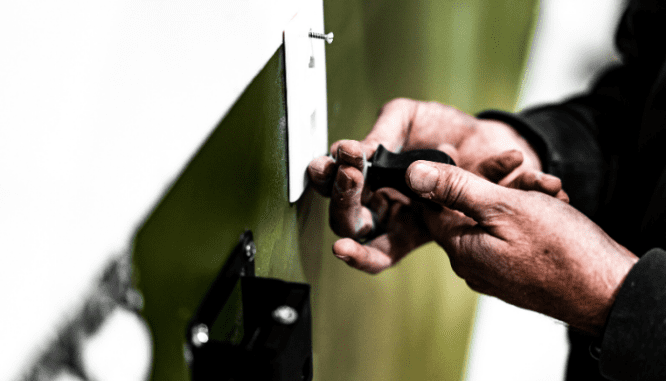 Hands doing some home maintenance work with a screwdriver.