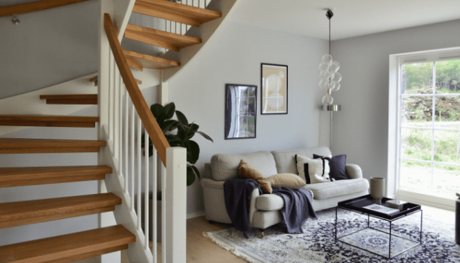 A floating staircase in a purple and beige themed living room.
