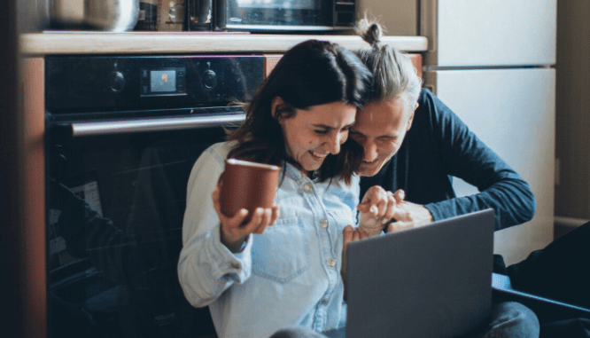 A couple using a laptop together in their kitchen to look for a contractor.