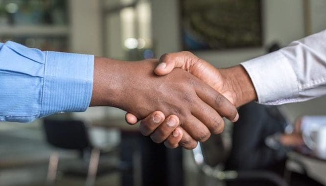 Two men shaking hands who are partners in the short sale buying process