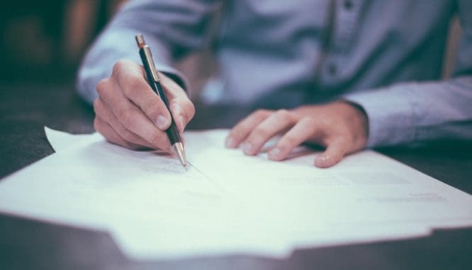 A man signing papers in the short sale buying process