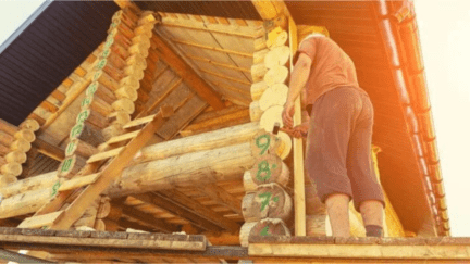 A man building a log house himself as part of a build your own house program