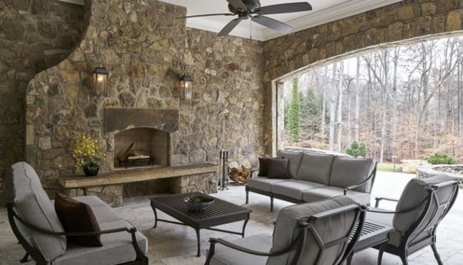 A patio in a backyard with a fireplace.