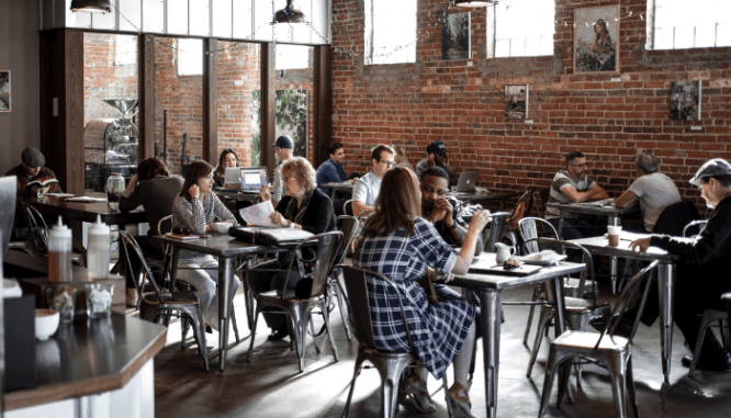People discussing investing in foreclosures at a coffee shop.