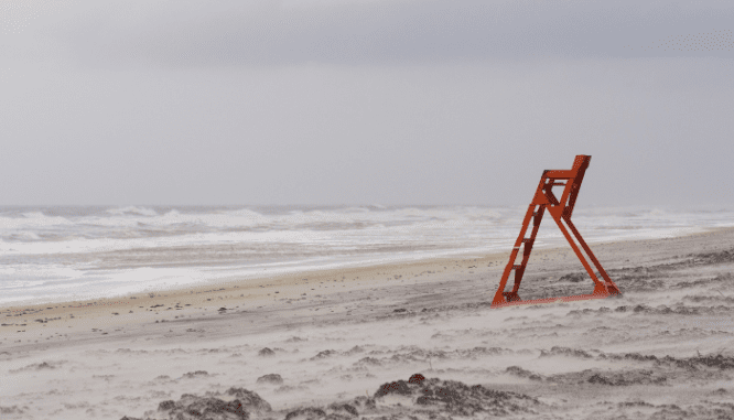 a lifeguard stand on a beach during a hurricane that created a housing crisis.