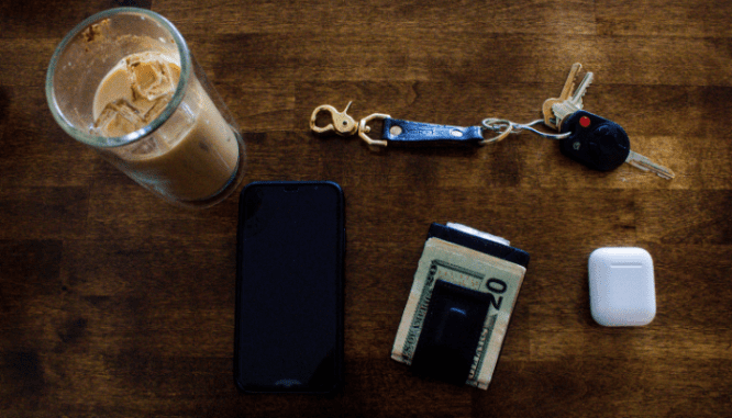 A table with keys, wallet, and a phone used to buy a house during coronavirus.