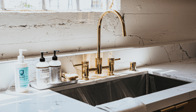 A brass faucet that is a 2021 home design trend stolen from another decade.