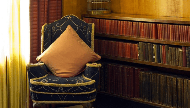 A chair and book shelf with art deco interior design.