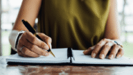 An image of a woman writing a due diligence real estate checklist.