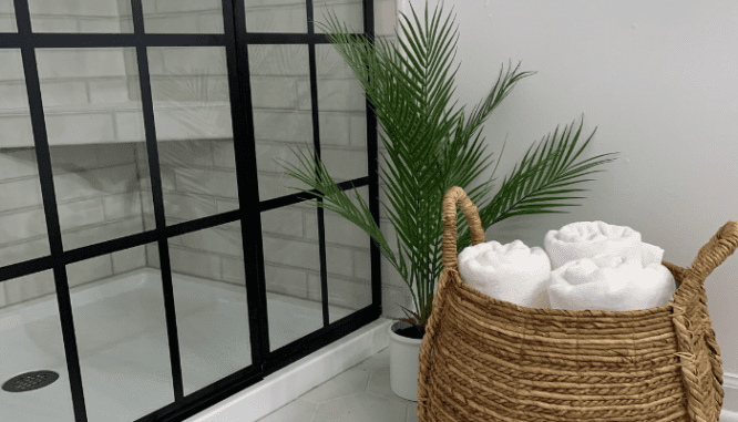 A plam tree and towels in a cheap bathroom remodel.