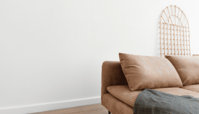An image of a couch and pillows to demonstrate the process of furnishing a new home.