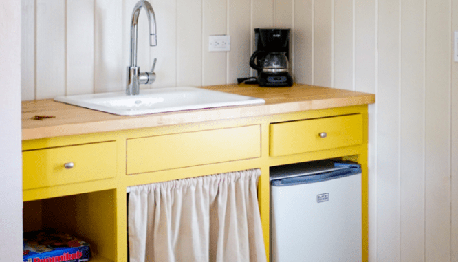 An image of a yellow kitchenette.