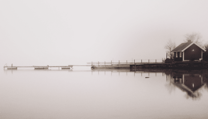 An image of a house on a lake to demonstrate what happens to a home sale during a flood.