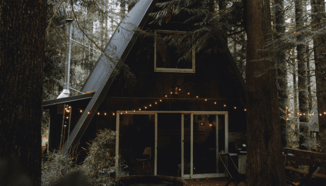 An image of an A-frame house with lights to depict what an A-frame house is.