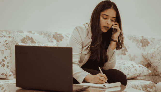 A woman sitting on a couch looking to buy a home in Manhattan.