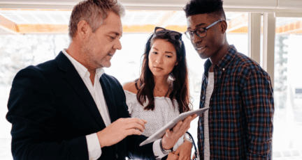 An image of a couple with a realtor to demonstrate that dual agency is illegal in some states.