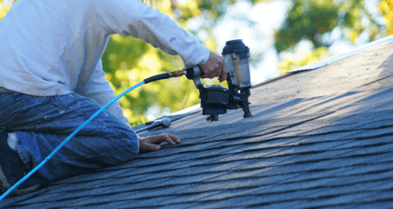 An image of a roof repairman working to demonstrate how much it would cost to replace a roof.
