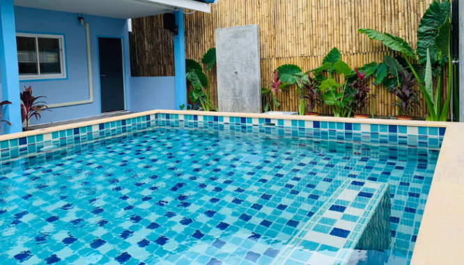 A backyard pool featuring a baja shelf idea in the design.