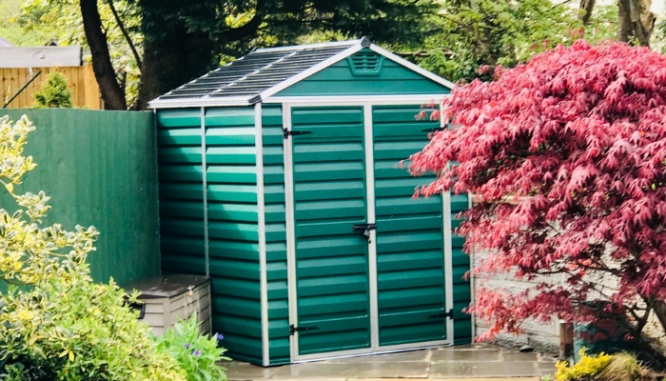 A storage shed painted a bright teal which adds to the cost to build a shed.