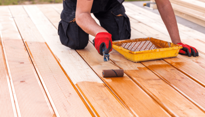 A professional contractor that is staining a deck.