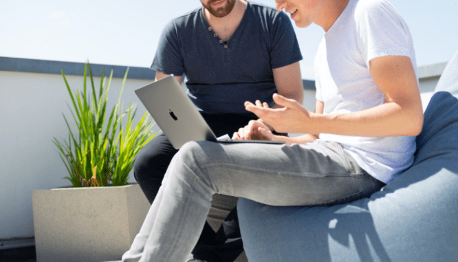 An image of two people talking to demonstrate how to make an offer on a house with a realtor.