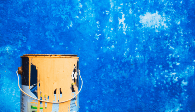 A paint bucket used while painting trim white.