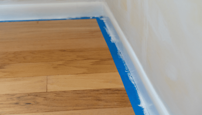 Tape on the floor while painting trim white.