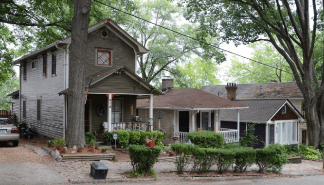 Three shotgun houses close together on a neighborhood street.