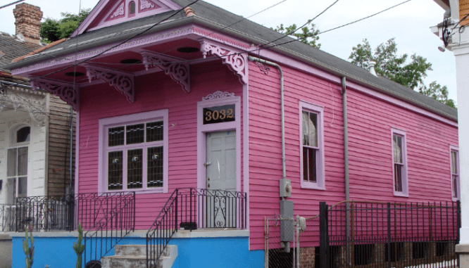 A pink shotgun house that has a simple floor plan on the inside.