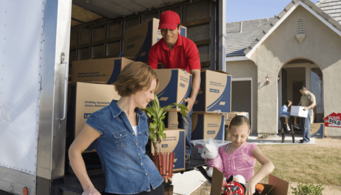 A family packs up their moving truck, a factor to consider when deciding whether to add on or move.
