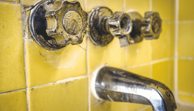 An outdated shower in need of a bathroom remodel.