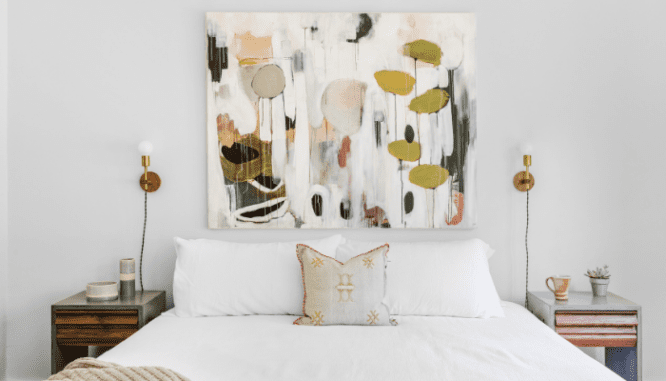 a bedroom with wall sconces, which can help organize a small room.