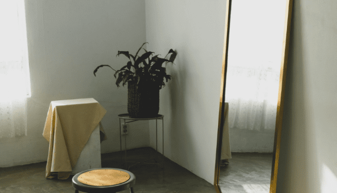 A full length mirror leans against the wall, which is one way to decorate with mirrors.