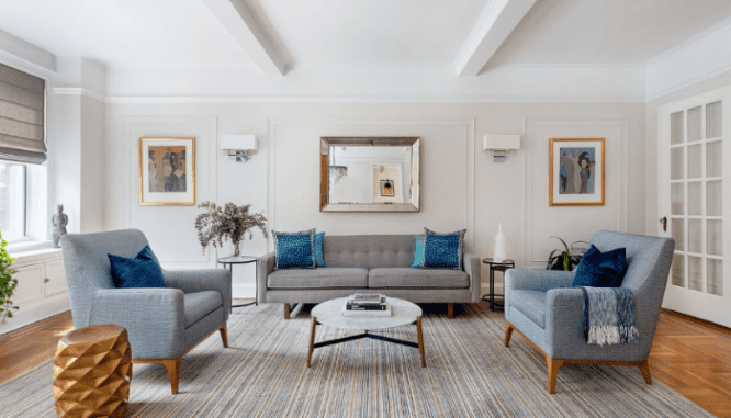 A large mirror hangs behind a sofa to create a focal point, which is one way to decorate with mirrors.