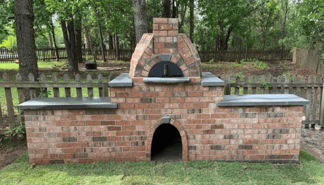 A pizza oven made of brick that will be used with landscaping.