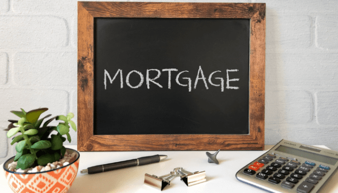 A chalkboard and calculator used to determine how much a mortgage payment will be.