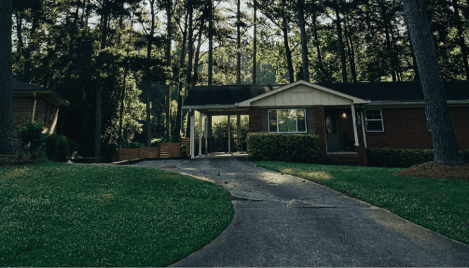 A concrete driveway with significant cracks so the homeowners need to learn how to fix driveway cracks.