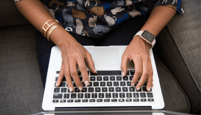 A woman types on her laptop questions to ask a mortgage broker.