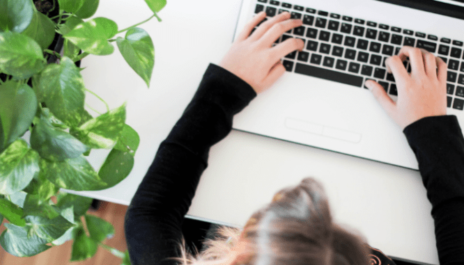 A woman types on a laptop her questions to ask her mortgage broker.