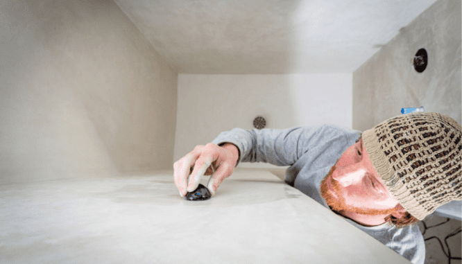A tadelakt artisan installs the plaster in a home shower.