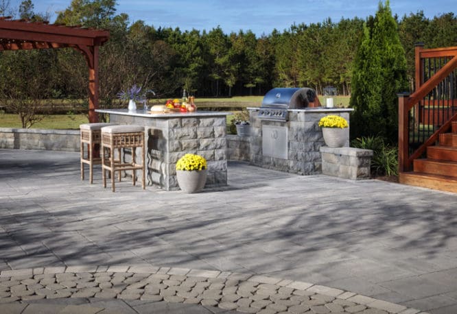 An outdoor kitchen that is part of an outdoor room.