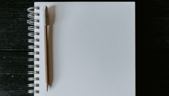 A pencil and notebook used to calculate carrying costs in real estate.