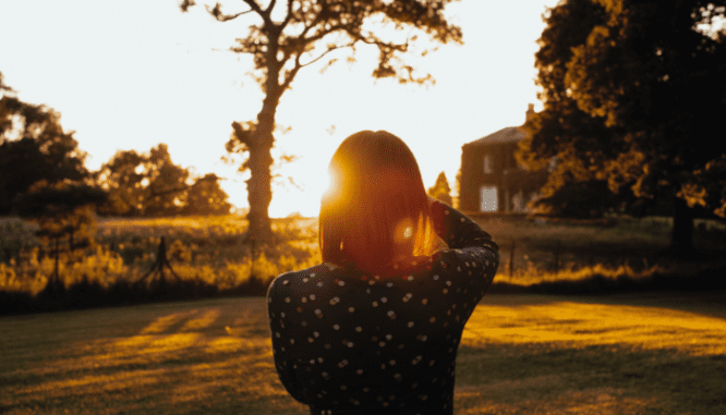 An image of a person with a sunset to demonstrate the process of how to buy a foreclosure.